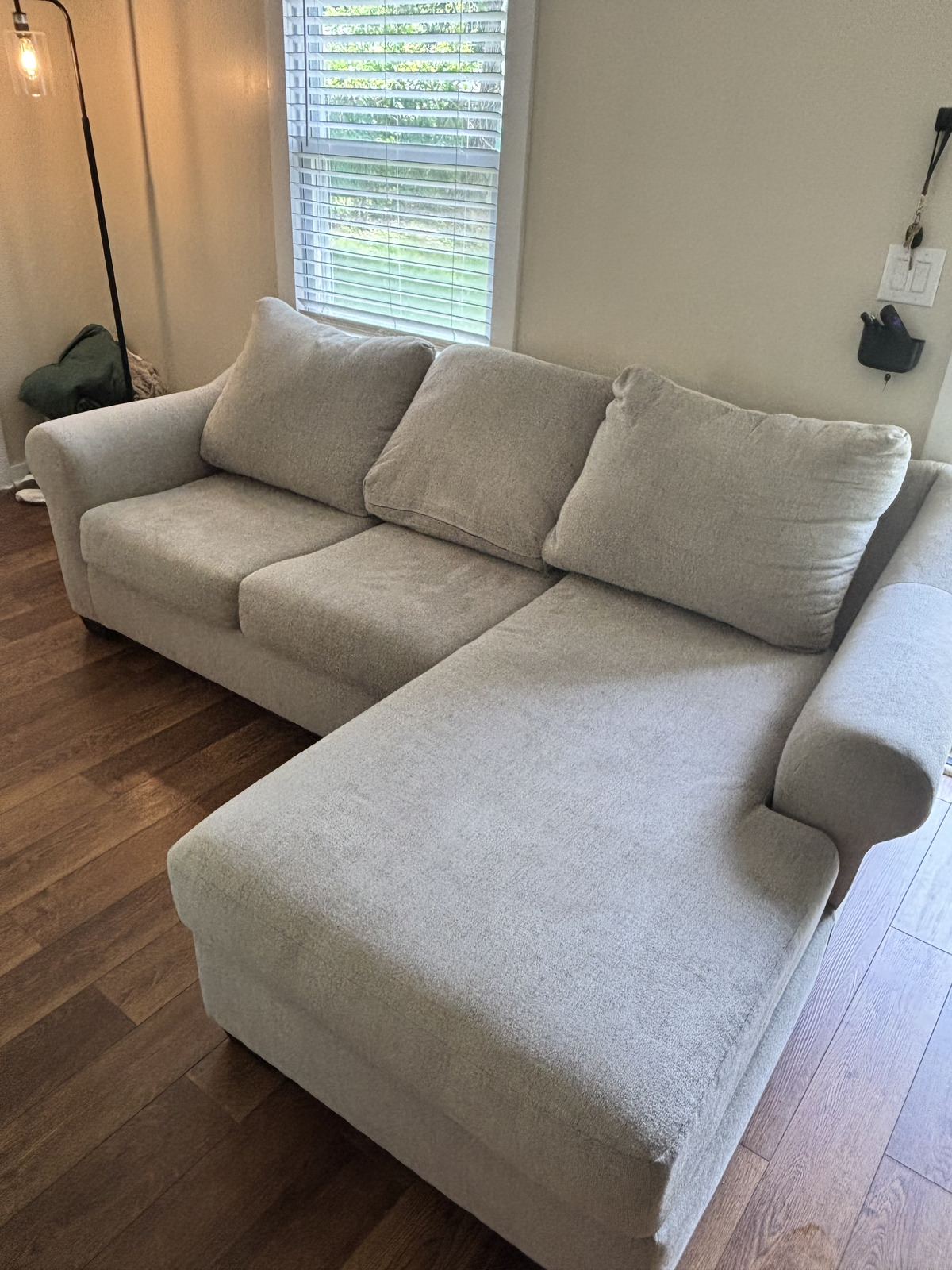 Three-seat grey fabric sofa after a deep clean