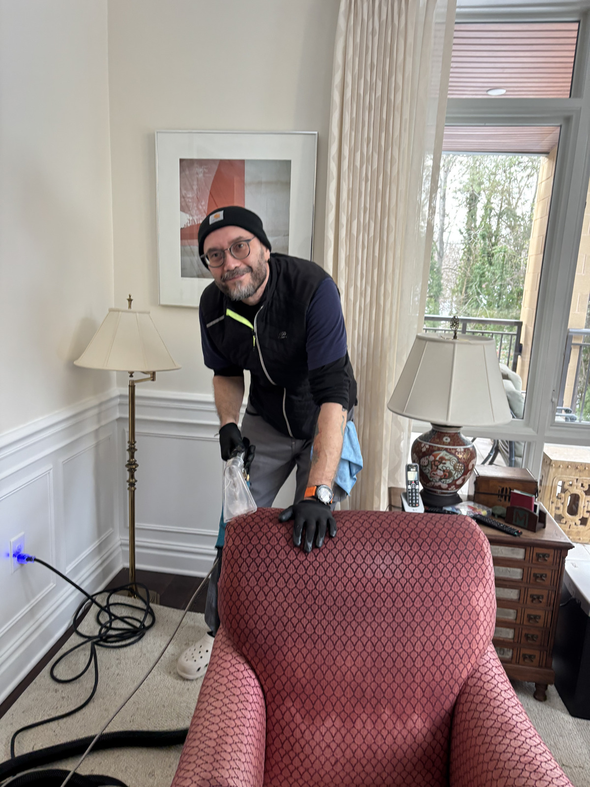Technician cleaning a red accent armchair