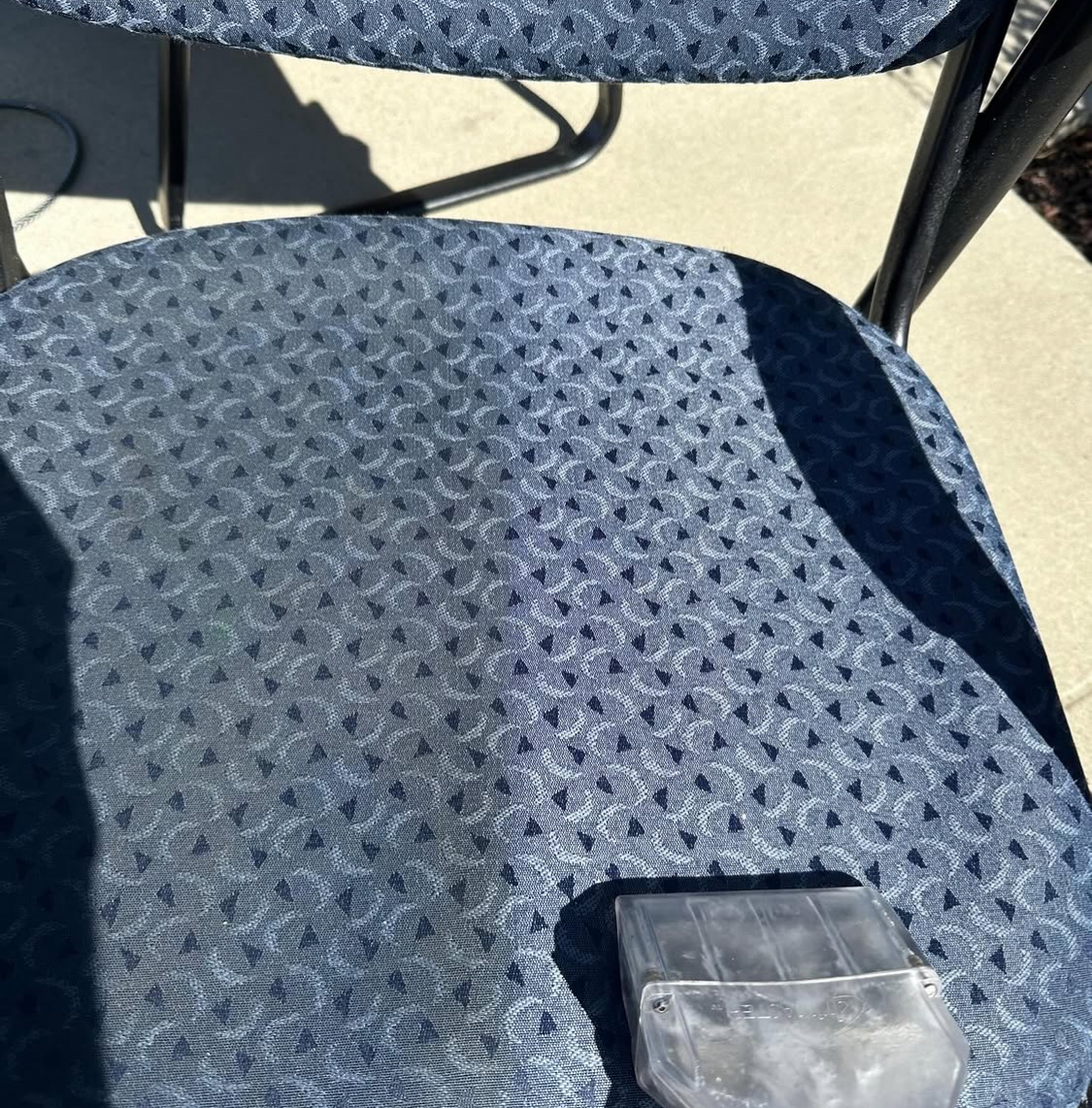 Patterned patio chair being cleaned outdoors